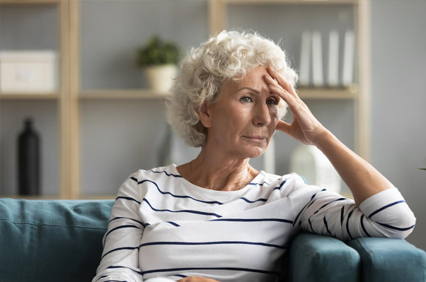 Image depicting a dimly lit room with an elderly person exhibiting signs of agitation or confusion during the evening, representing sun downing behavior in individuals with dementia.